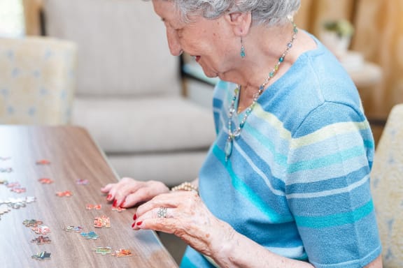 an older woman playing cards with others at a table