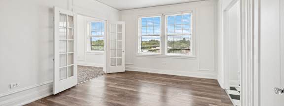 an empty living room with white walls and a ceiling fan at CWE Apartments, St. Louis, 63108