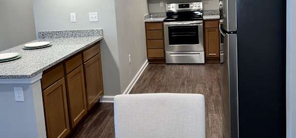 a kitchen with stainless steel appliances and a table with a cake