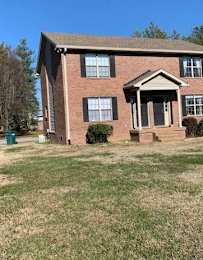 a brick house with a lawn in front of it