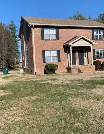 a brick house with a lawn in front of it