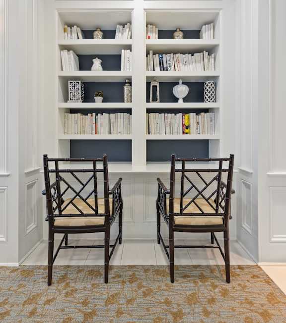 A hallway with a table and chairs in the middle.