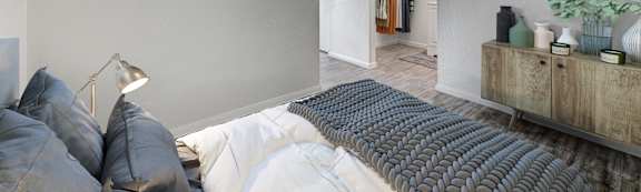 A bedroom with a bed, pillows, and a lamp.