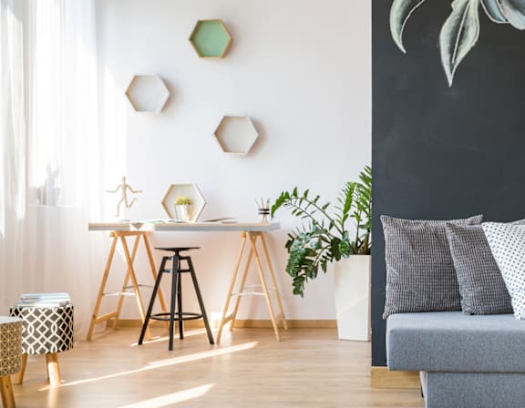 a living room with a couch and a wall with a painting of flowers