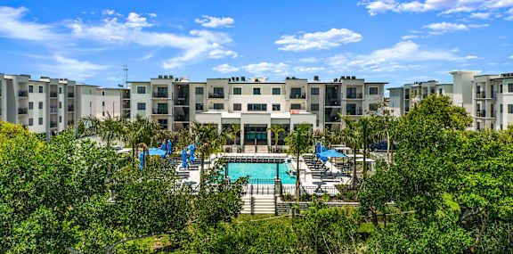 outside view of the pool area and greenery around the complex