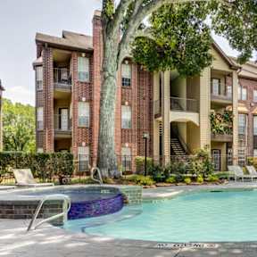 A large apartment complex with a pool in the foreground.