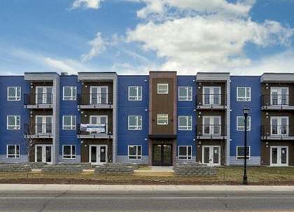 A row of apartment buildings with a cloudy sky above.