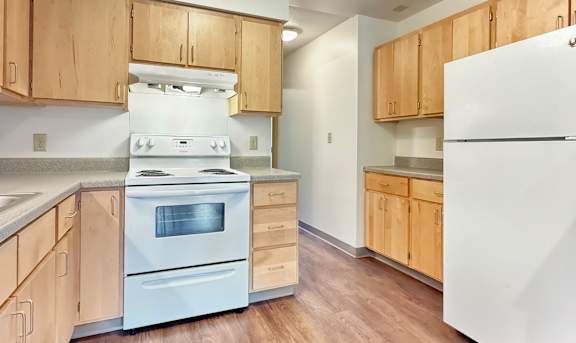 A kitchen with wooden cabinets and white appliances.