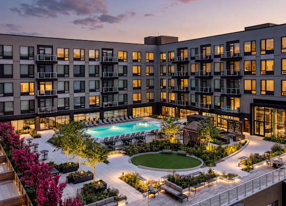 A modern building with a pool and a beautiful sky.