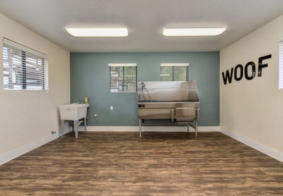 Dog Spa Tub with Hardwood Inspired Floor, Dog Washing Tub, WOOF Written in Black Letters on Wall, and Fluorescent Lights