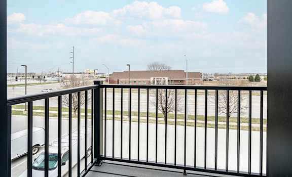 a balcony with a view of a parking lot and a building