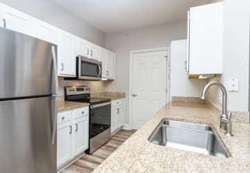 Drum Hill model apartment kitchen with high quality finished, stainless appliances, and granite counters. 