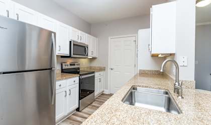 Drum Hill model apartment kitchen with high quality finished, stainless appliances, and granite counters. 