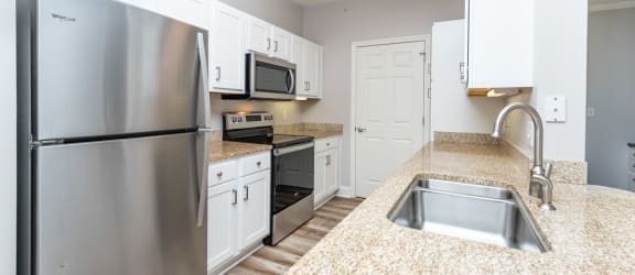 Drum Hill model apartment kitchen with high quality finished, stainless appliances, and granite counters. 