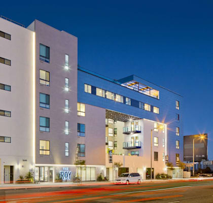A modern multi-story building with a white facade and blue accents.