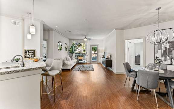 A dining room with a table set for two and a view of a bedroom through the door. at The Royce at 8100, Austin, TX, 78729