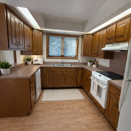 A kitchen with a stove, sink, and cabinets.