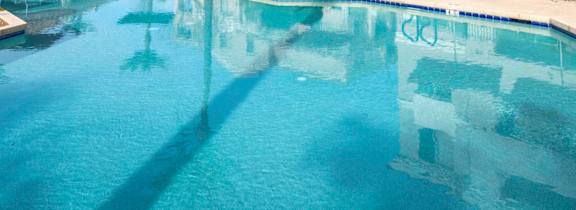A large swimming pool in front of a building with palm trees.at Vintage at Scottsdale, Arizona, 85260