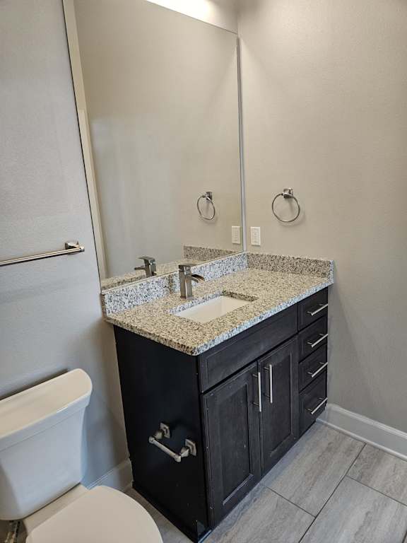 A bathroom with a black cabinet and a white toilet.
