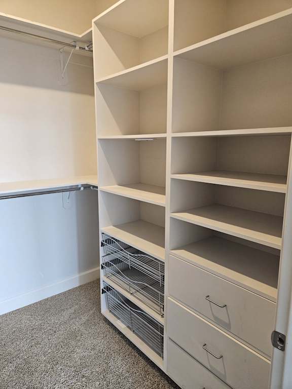 A white shelving unit with a white door and a white wall.