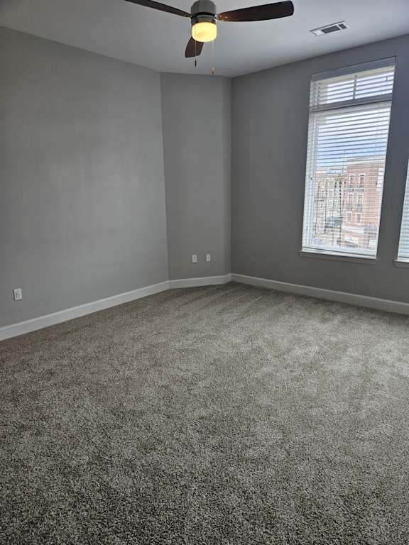 A room with a grey floor and a grey wall with a window.
