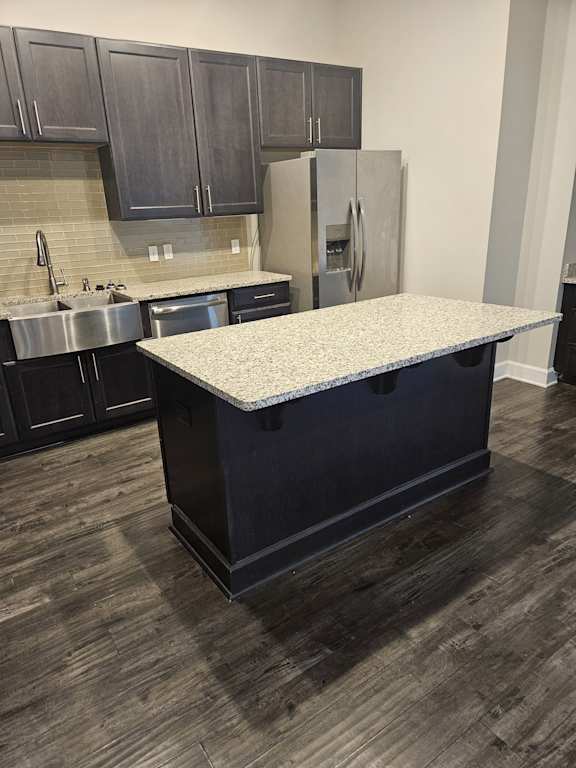 A kitchen with black cabinets and a stainless steel stove top.