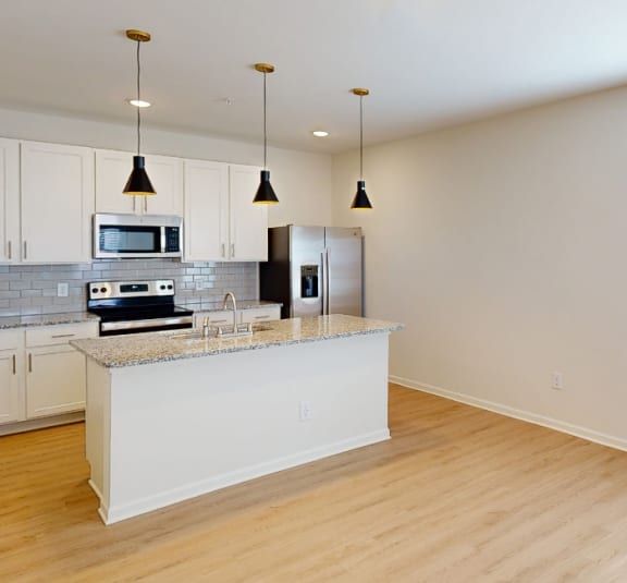 a kitchen with an island and a stove and a refrigerator