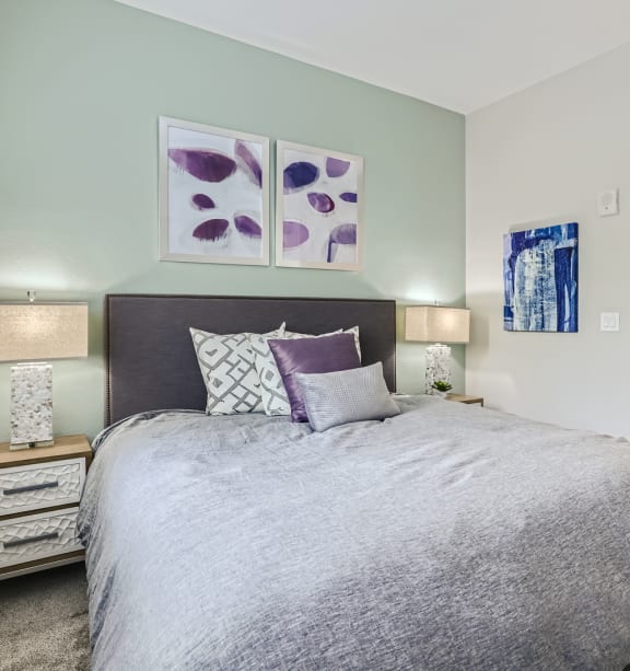 a bedroom with a large bed and two night stands with lamps