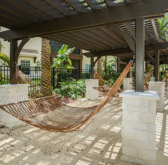 A hammock is strung between two wooden posts on a patio.