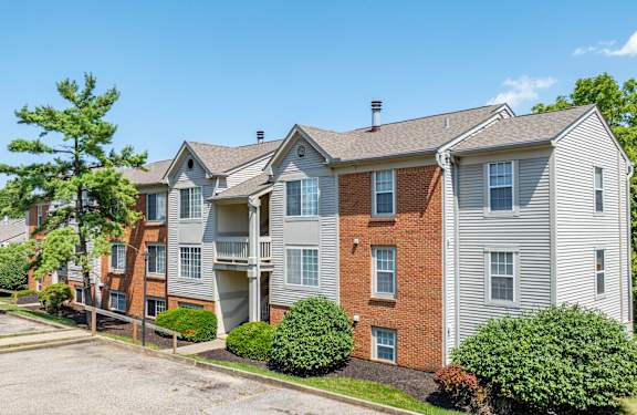 Apartment complex with a parking lot in front.