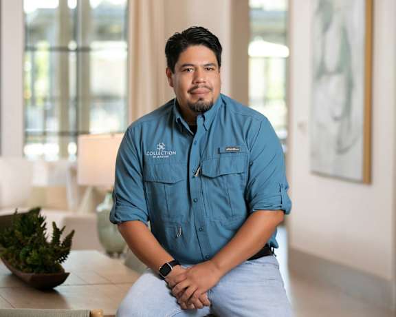 A man in a blue shirt is sitting on a bench.