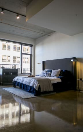 a bedroom with a bed and a large window in a loft at Garment Lofts, Los Angeles California