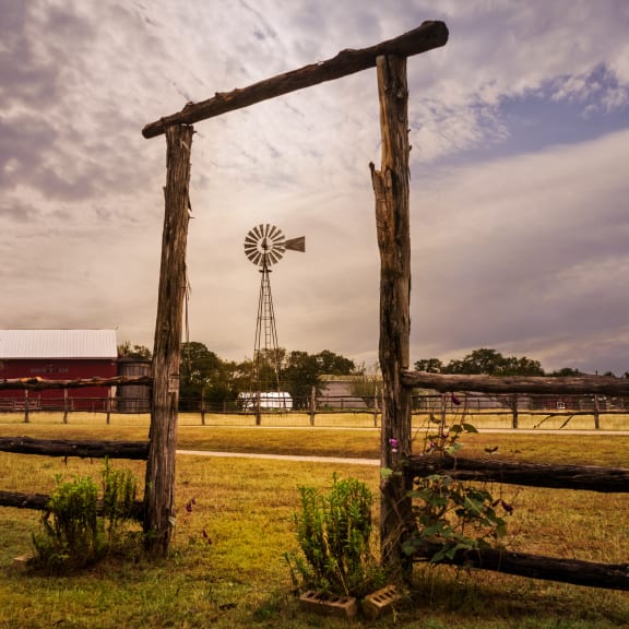 a windmill in a field with a wooden fence