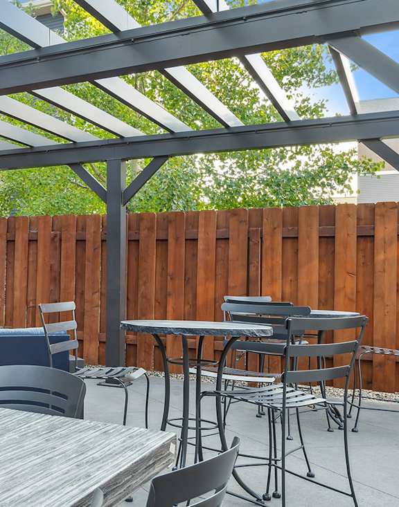 A patio with a table and chairs under a roof.