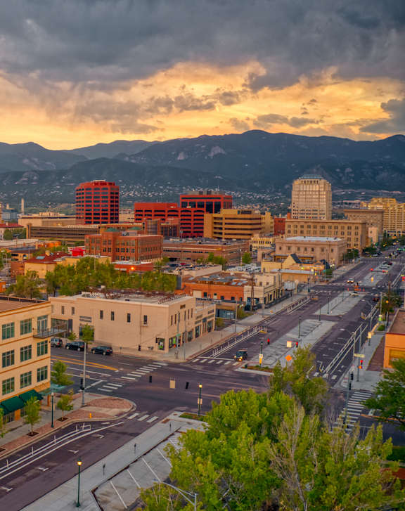 A cityscape with buildings and mountains in the background.