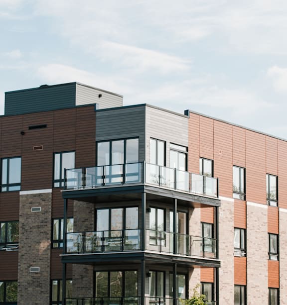 A modern multi-story building with balconies and large windows.