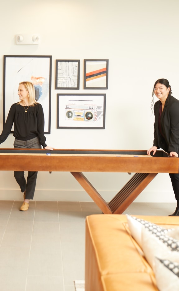 three women standing around a wooden table in a living room at Presidium Revelstoke, Fort Worth, TX, 76131