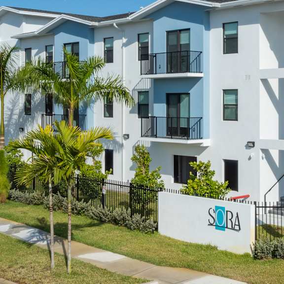 A white and blue apartment building with the name SORA on the front.