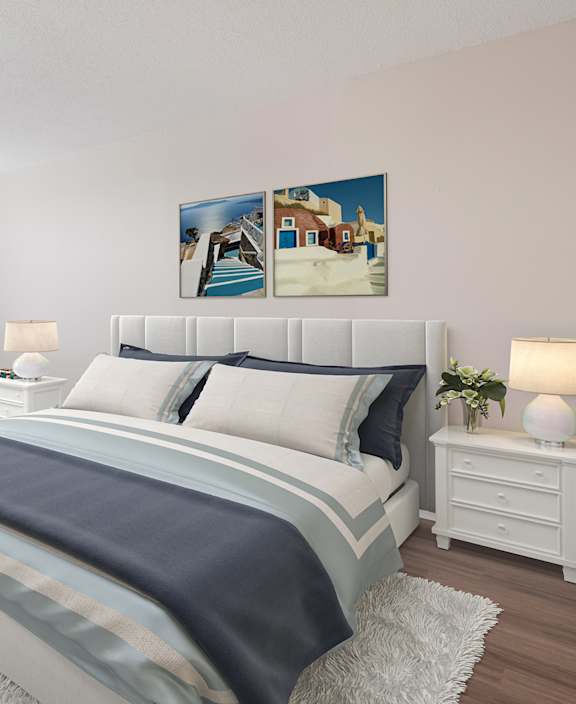 A bedroom with a large bed, a blue chair, and a painting on the wall.