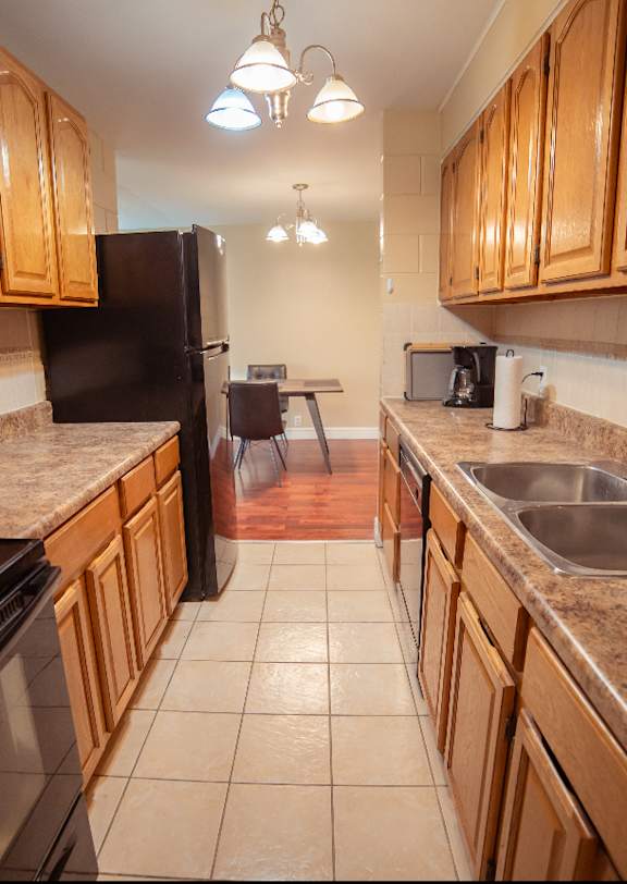 a kitchen with wooden cabinets and a black refrigerator