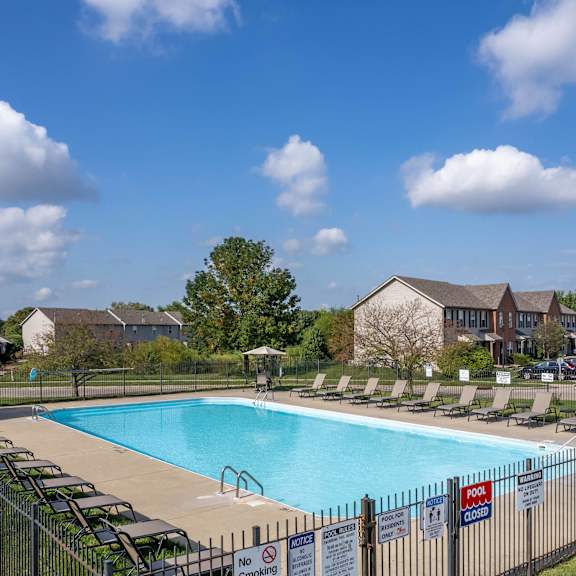 A large swimming pool surrounded by lounge chairs and umbrellas.