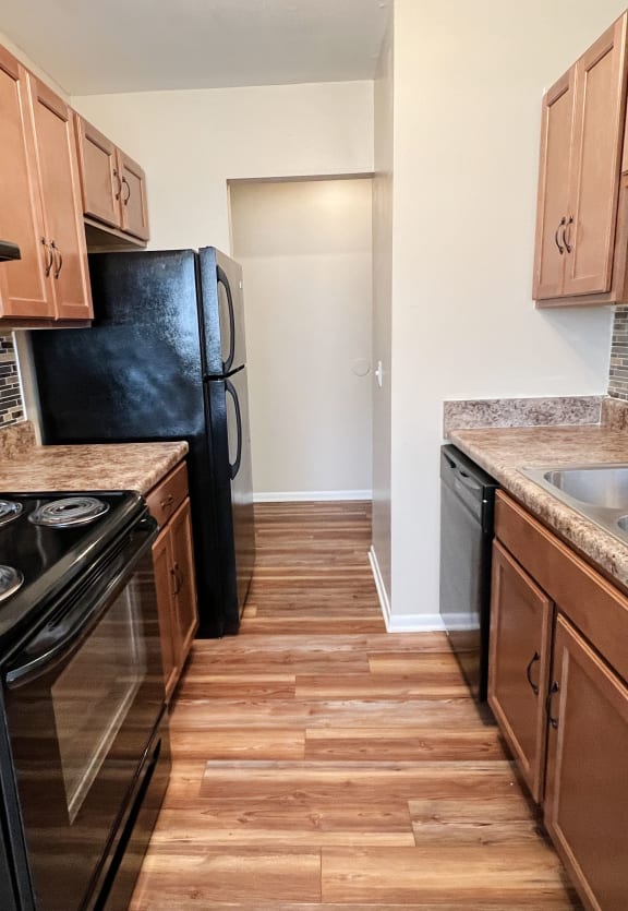 a kitchen with black appliances and wooden cabinets at Sharondale Woods Apartments, Cincinnati, OH, 45241