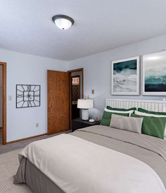 A bedroom with a large bed and two framed pictures on the wall.