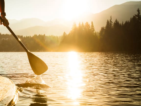 a woman standing on a paddle board on a lake at Mountain Vista, California