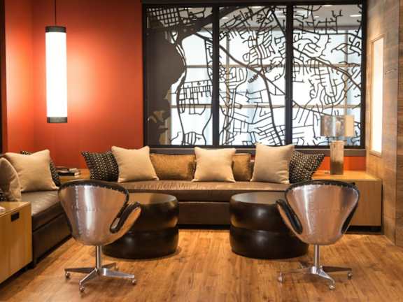 A living room with a couch, two chairs, and a lamp.