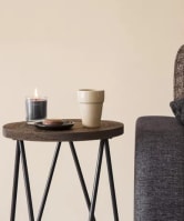 a couch and a table with a candle and a cup on it