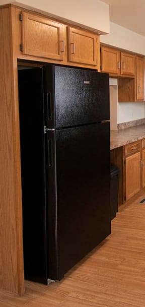 a kitchen with white cabinets and a black stove and refrigerator