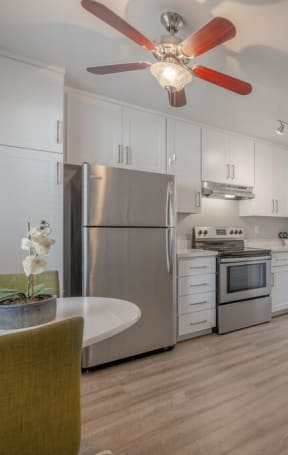 a kitchen with white cabinets and a ceiling fanat Napa Green Apartments LLC, Napa, 94559
