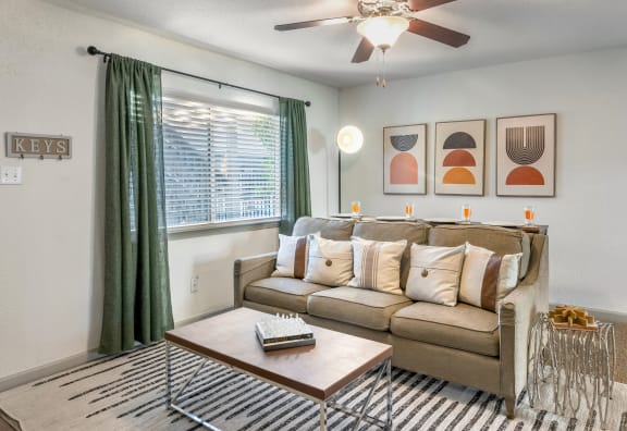 a living room with a couch coffee table and a ceiling fan