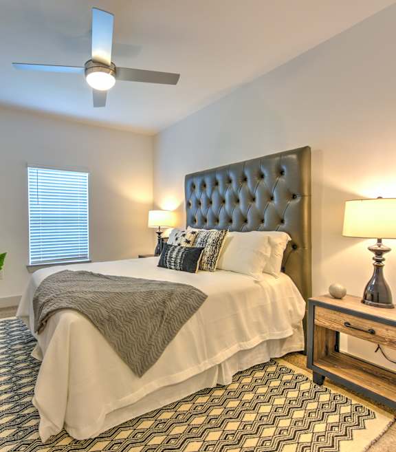 A bedroom with a large bed and a painting on the wall.